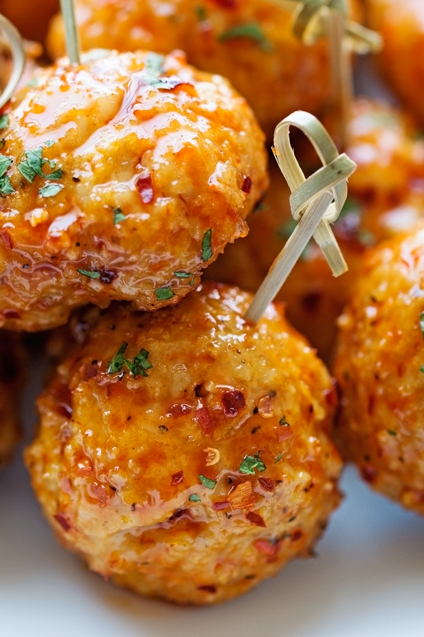 close up of chicken meatballs in firecracker sauce with appetizer sticks