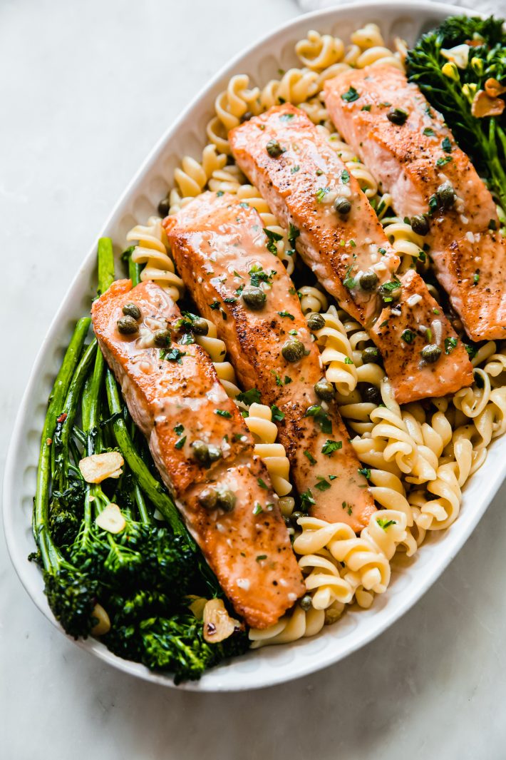 broccolini with garlic chips, salmon, pasta, drizzled in caper butter sauce