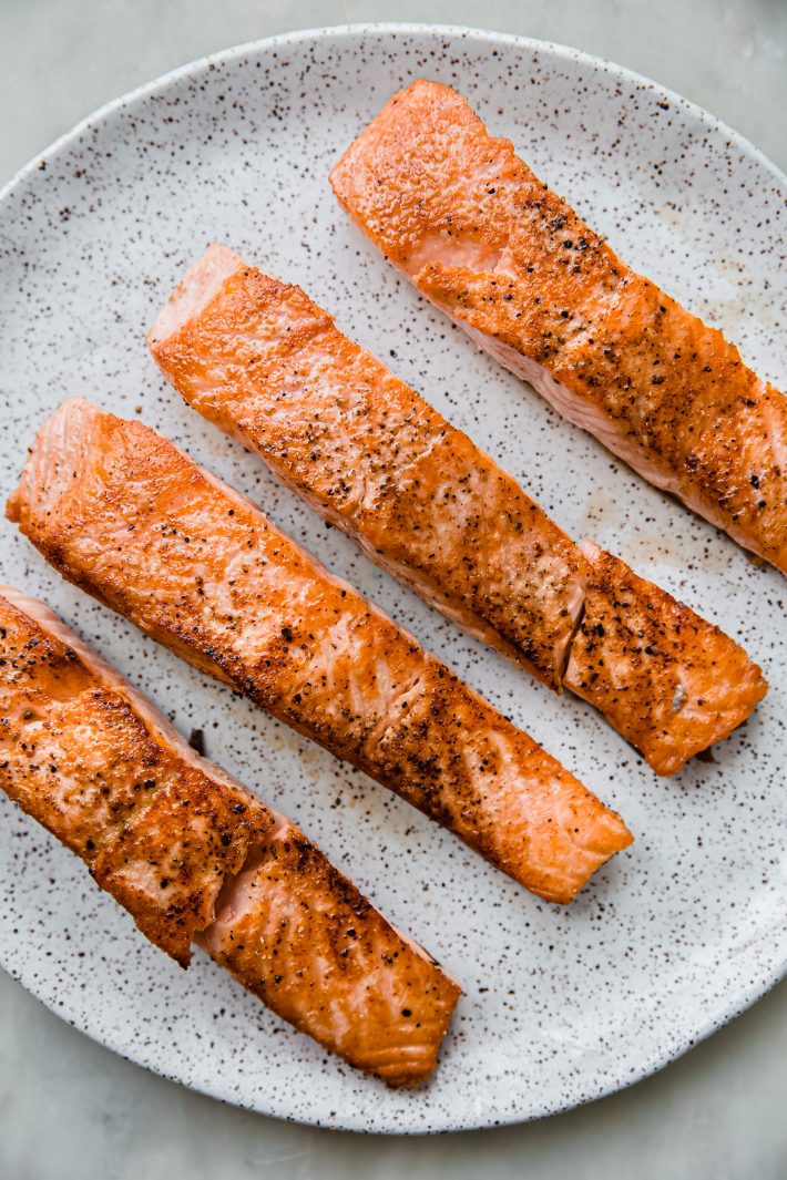 seared salmon fillets on speckled plate