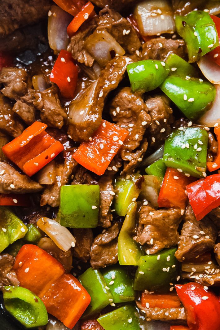peppers and steak topped with sesame seeds in pan