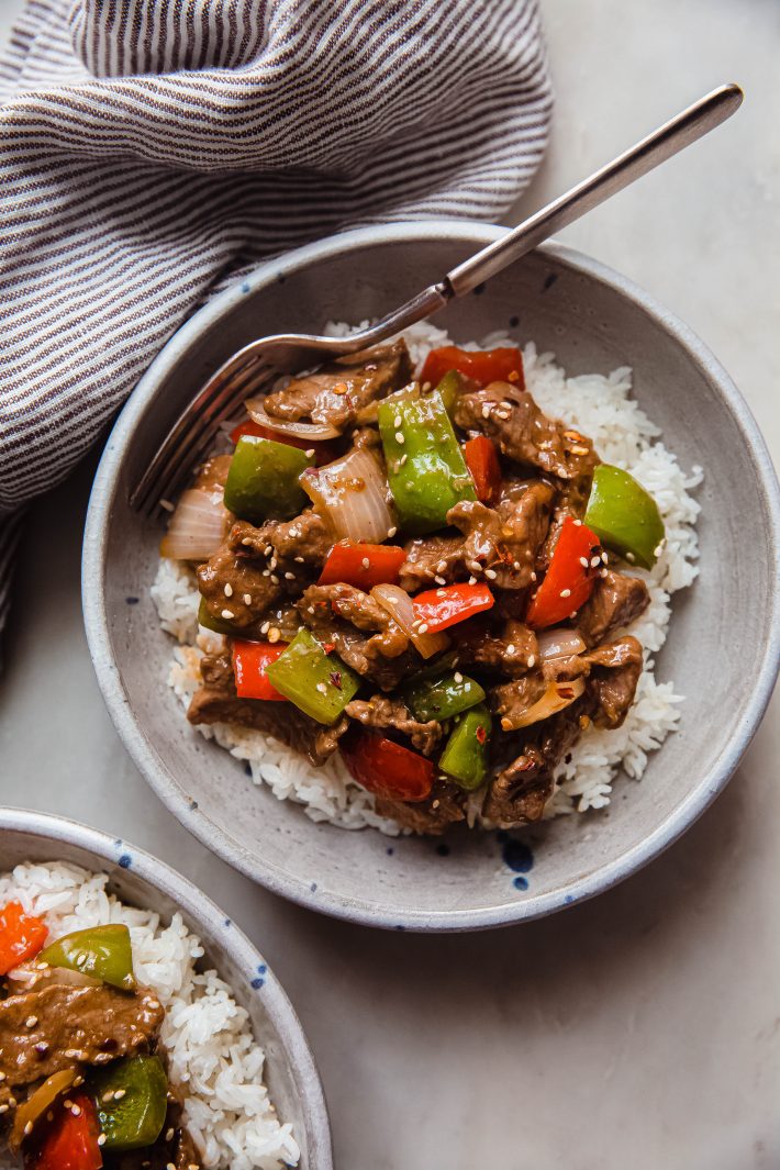 bowl of rice topped with pepper steak stir fry
