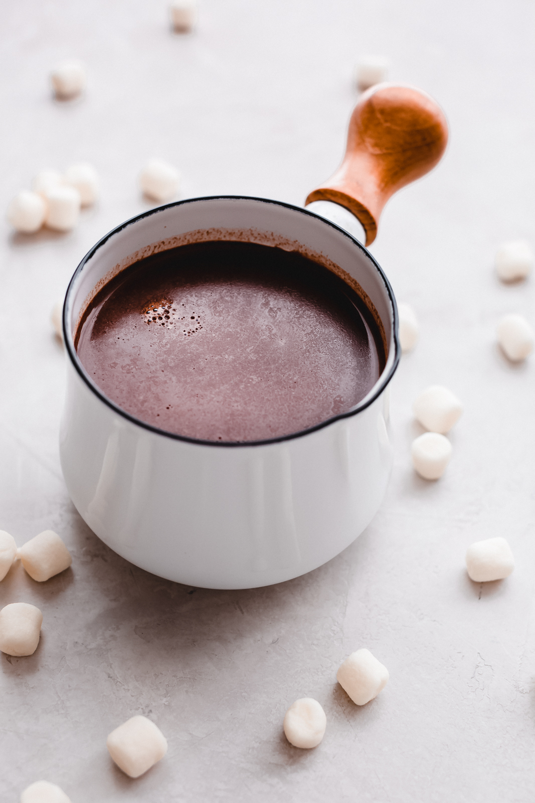 hot chocolate for two in a white saucepan with wooden handle