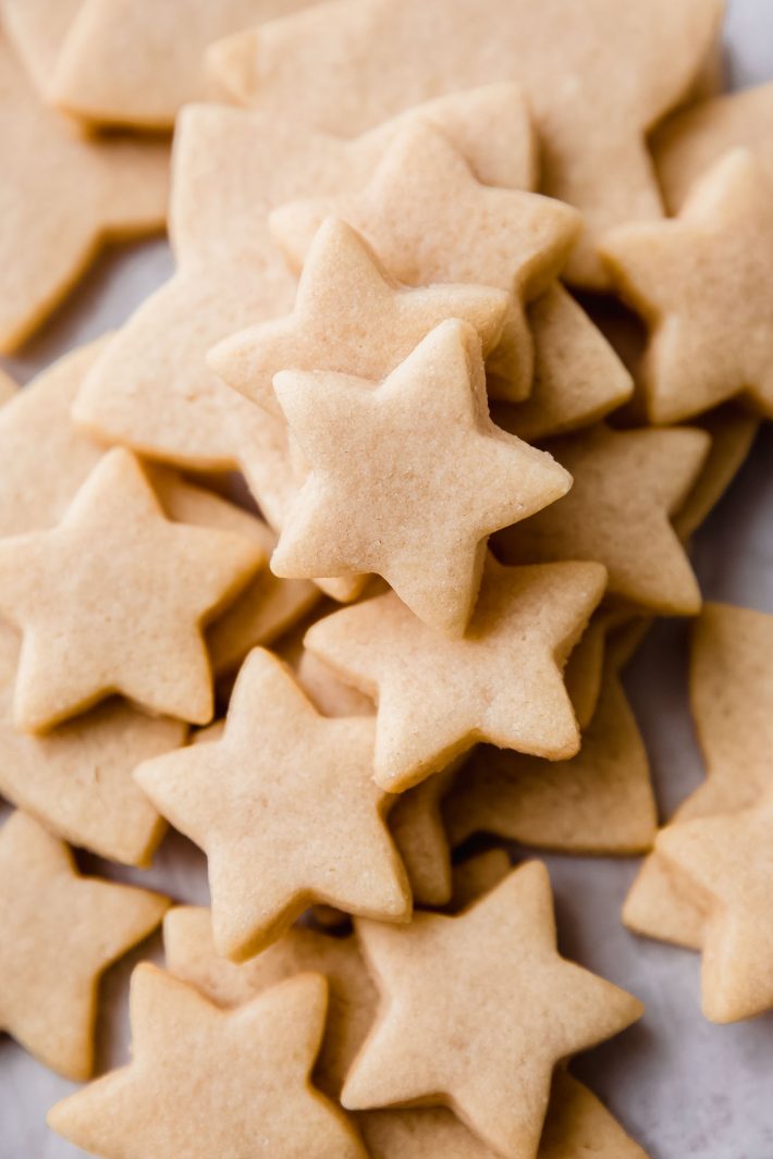 baked star shaped sugar cookies on white parchment