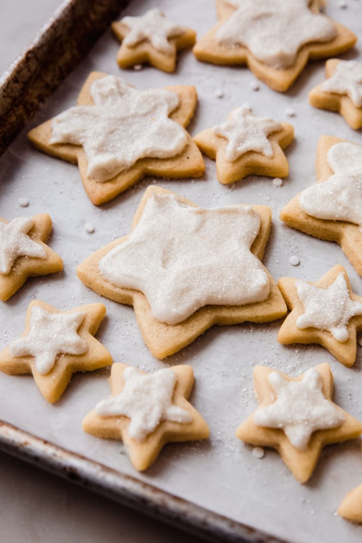 baking sheet filled with star shaped frosted cookies