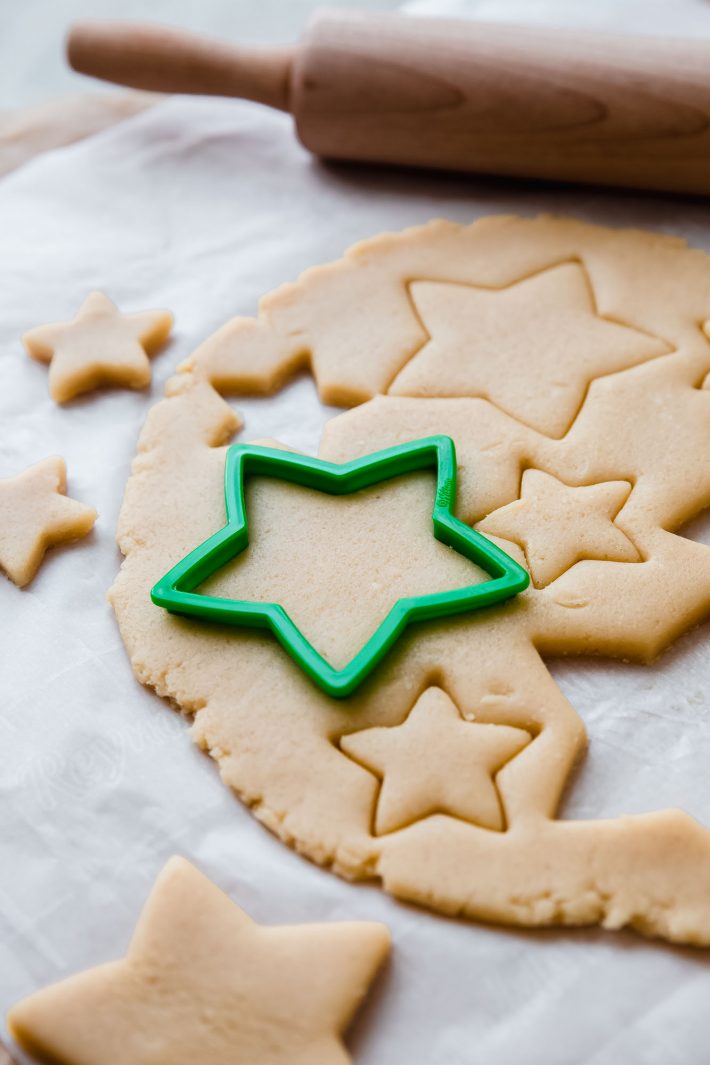 sugar cookie dough with star cut out on white parchment