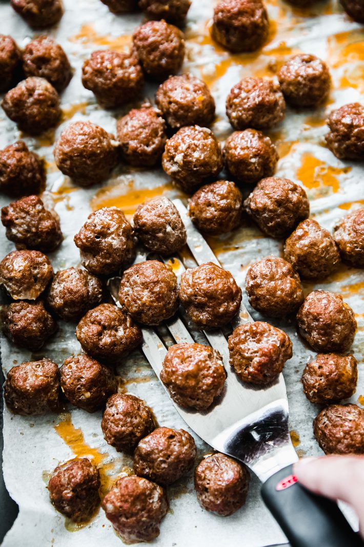 mini meatballs on sheet pan with spatula