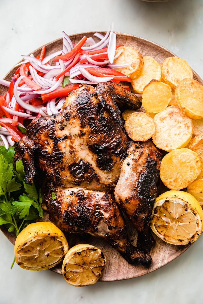 grilled chicken with potatoes on wooden plate