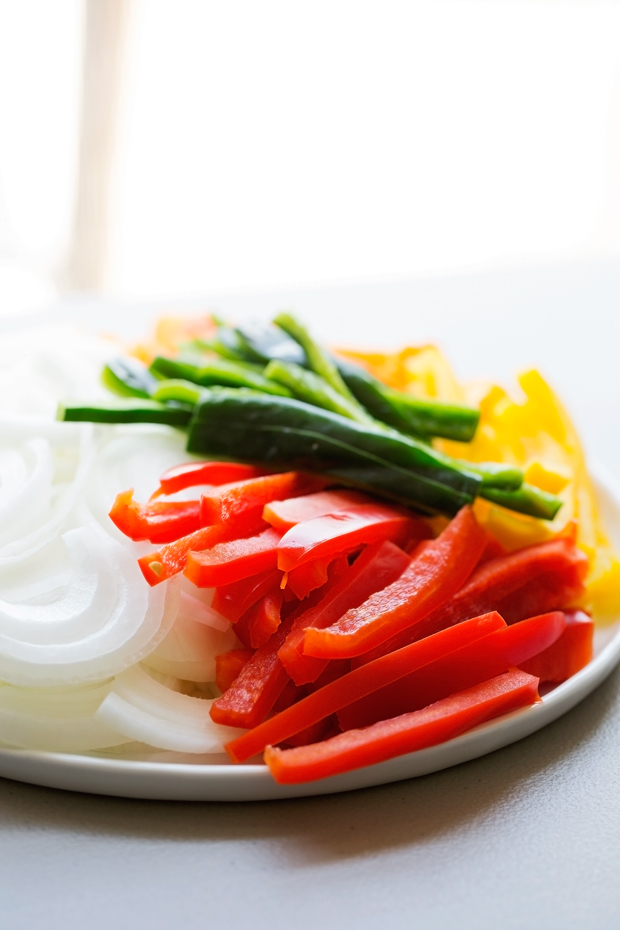 thinly sliced peppers and onions on a white plate