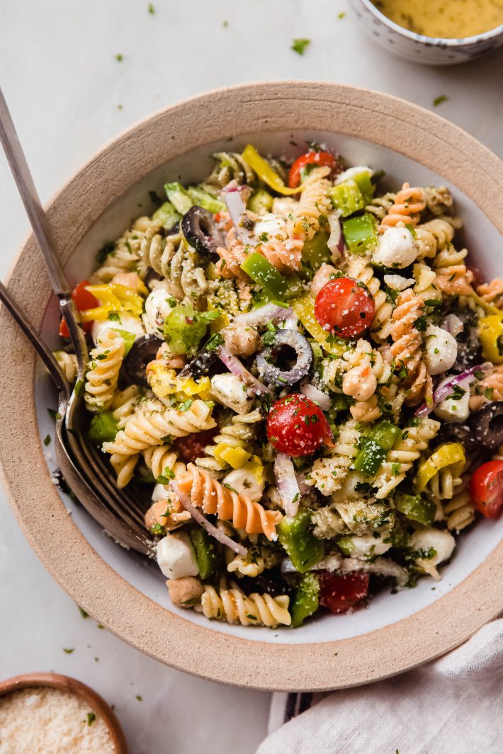 italian pasta salad in rimmed bowl on white marble