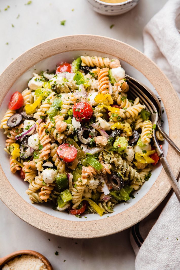 pasta salad in rimmed plate on white marble