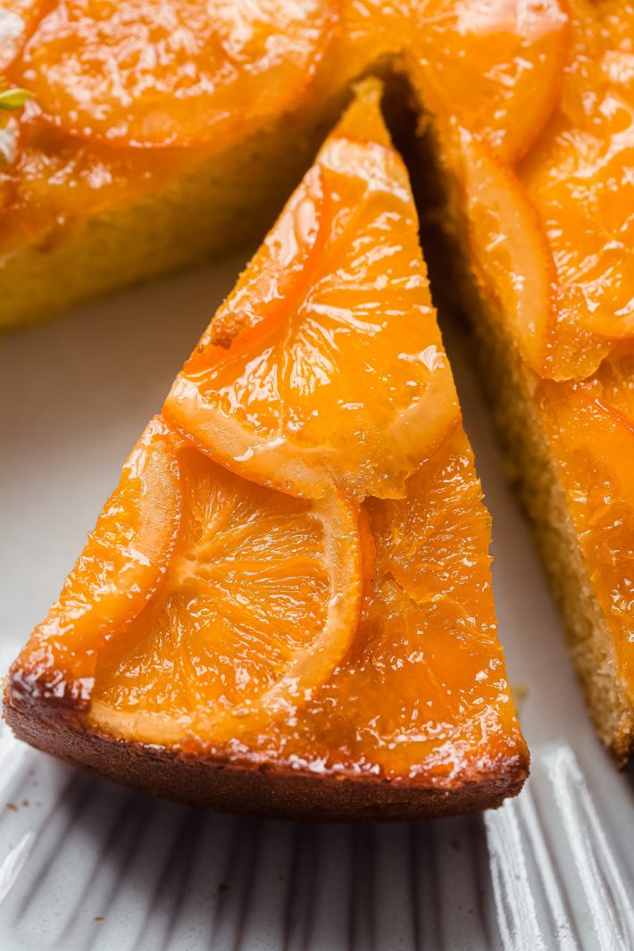 slice of whole orange cake with candied oranges on top